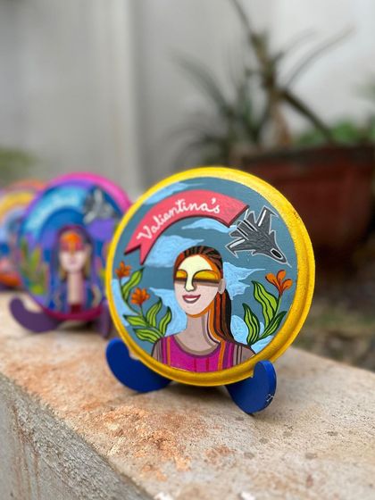 A single mini plate displayed on a stand, showing the detail of the portrait and the fighter jet motif.