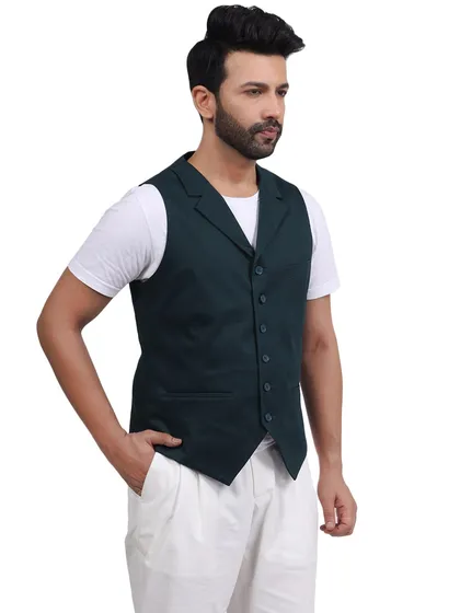 A model sports a casual look with a dark green vest and white trousers. This demonstrates our ability to shoot relaxed, lifestyle-oriented fashion for contemporary brands.