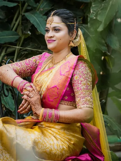 This bride chose a classic yellow and pink Kanchivaram for her wedding. The blouse is heavily embroidered in gold, matching the richness of the saree's border.