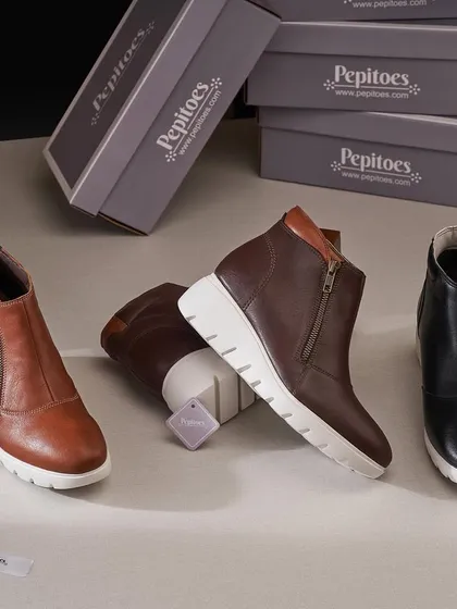 A group shot of ankle boots from Pepitoes. By stacking the boxes in the background and arranging the boots in a dynamic way, we created a shot that feels more like a scene from a stylish stockroom than a simple product lineup.
