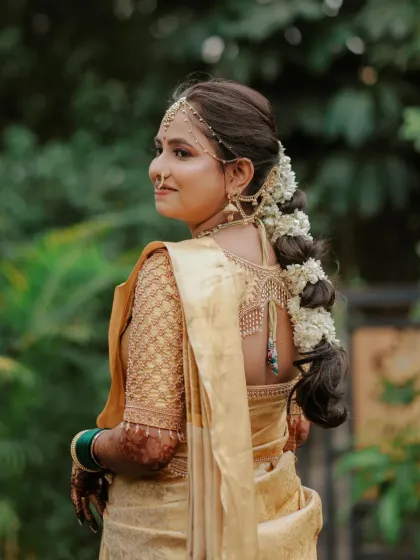 A detailed look at the back of Dhanashree's hairstyle, featuring a thick braid adorned with fresh jasmine flowers (gajra), a staple for Marathi brides.
