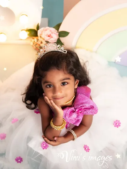 A close-up of the birthday princess. This portrait captures the sweet expression of a three-year-old girl, complete with a tiny tiara, during her birthday photoshoot.