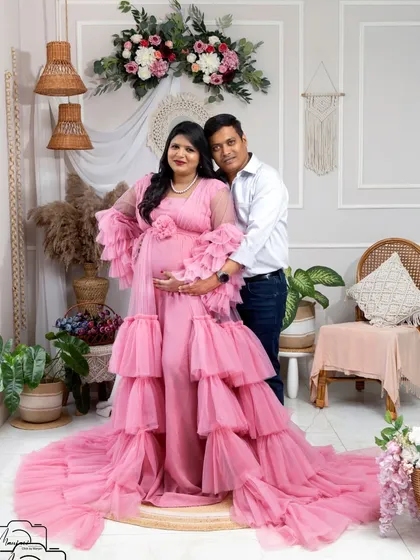 A classic portrait of the expecting couple, looking happy and relaxed in the beautiful boho studio.