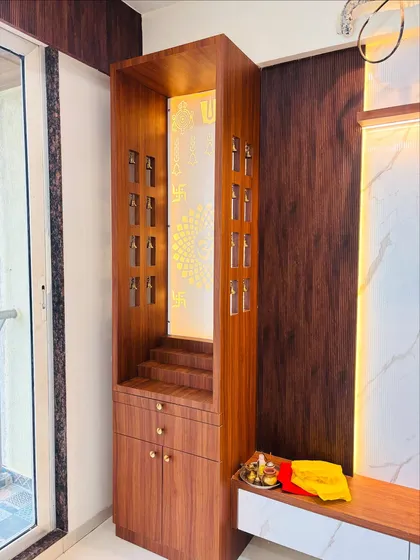 Another angle of the wooden mandir, showing the detail of the bell cutouts on the side panels.