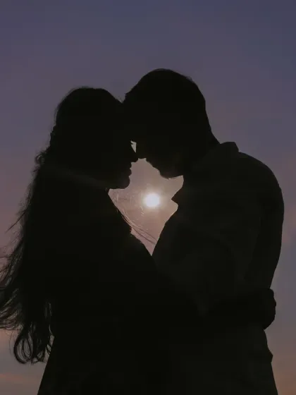 A stunning silhouette of a couple against a sunset, showcasing our artistic approach to creating dramatic and romantic pre-wedding portraits.