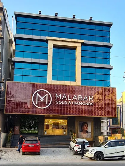 The facade of a completed commercial space for Malabar Gold & Diamonds in HSR Layout. This retail architecture project combines a sleek glass upper structure with a richly detailed ground-floor showroom, creating a premium and inviting brand experience.