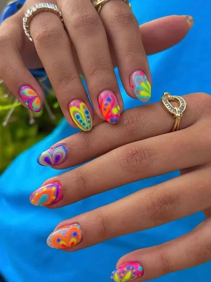 A vibrant and psychedelic 70s-inspired nail art design. The bright, swirling colors create a fun, retro look that is full of energy.