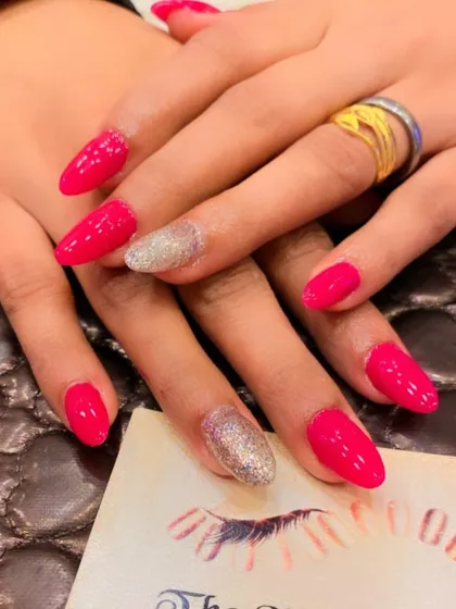 A bright and cheerful set of hot pink almond nails. The ring fingers are accented with a full coat of silver glitter for a classic glam look.