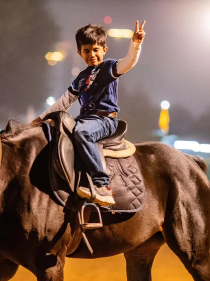 A joyful shot of a boy riding at night. Our well-lit arena allows for fun photoshoots even after the sun goes down.