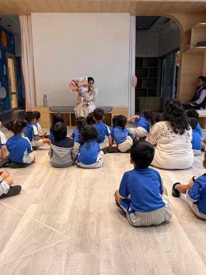 Even in a group, every child is captivated during storytime. Here, we're exploring the delightful book "How Do Dinosaurs Say Goodnight," showing that my sessions balance high energy with moments of focused calm and listening.