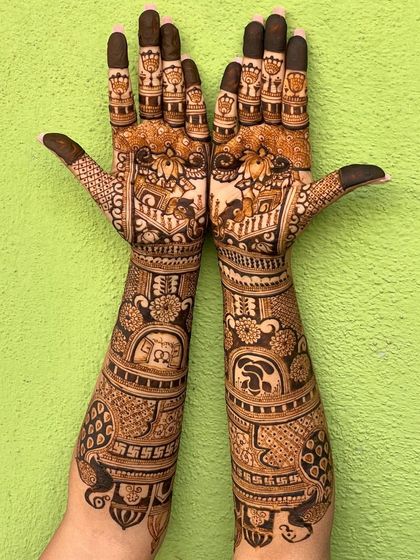 A full view of the intricate bridal mehendi, with personalized portraits and traditional motifs.