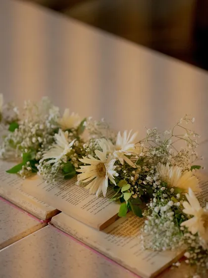 It's all in the details. For our storybook-themed baby shower, we used open books adorned with delicate baby's breath and daisies as part of the table decor, adding a touch of literary charm.