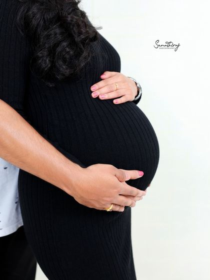 A close-up shot focusing on the hands of both parents cradling the baby bump. This simple yet powerful image represents the love and protection surrounding their unborn child.