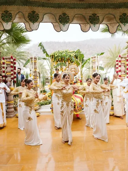 A wide shot of the performance, showcasing the coordinated dance and the beautiful traditional outfits.