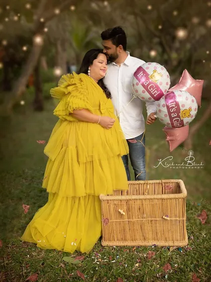 A beautiful portrait from the birth announcement shoot. The vibrant yellow dress and "It's a Girl" balloons create a joyful and celebratory image in a lovely garden setting.