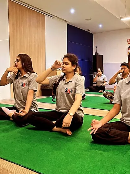 Employees at a corporate yoga session practicing Nadi Shodhana pranayama. This is an excellent technique to de-stress during a busy workday.