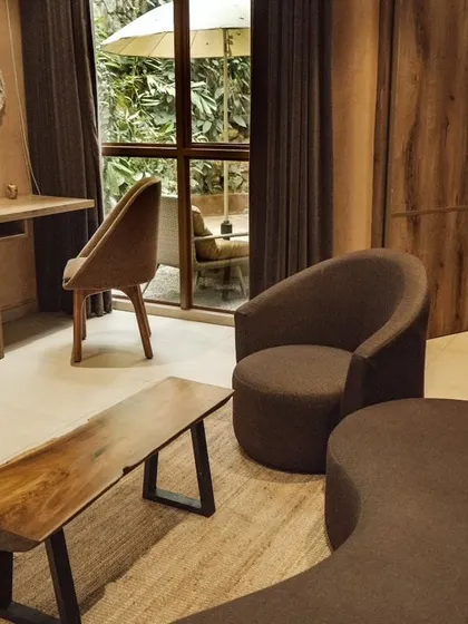 The stylish living area of a premium suite, with comfortable seating and a view of the private outdoor space.