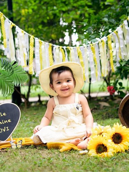 Our little sunshine in her sun hat. The personalized chalkboard sign is a sweet detail to add to any milestone photoshoot.