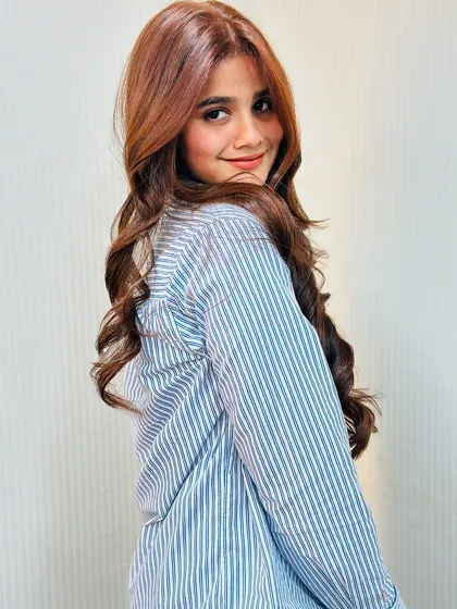 A happy client with a beautiful smile and even more beautiful hair, ready for her event.