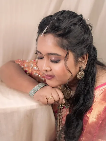 A serene portrait of a bride at her reception, looking down gracefully. The soft makeup enhances her peaceful expression.