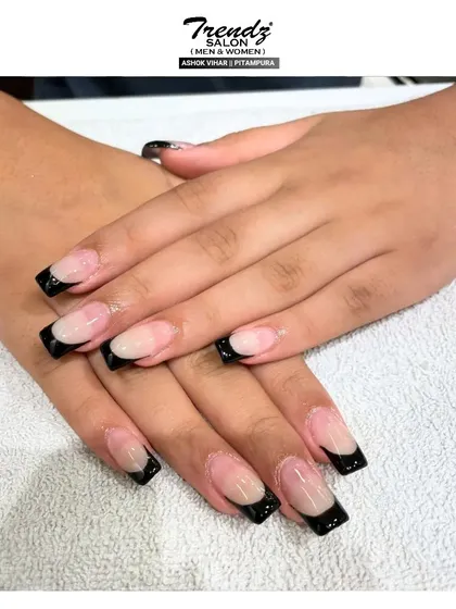 This is a close-up of the bold black French tip manicure on perfectly sculpted square extensions. The high-contrast look is modern, confident, and makes a definite style statement.