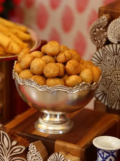A silver bowl filled with crispy, golden-brown kachoris. This popular Rajasthani snack is a savory delight and a key part of our authentic regional Indian menu.