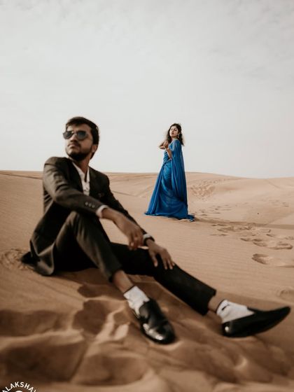 A creative composition with the groom seated in the foreground, giving the shot an editorial feel.