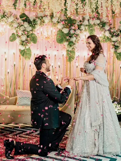 The classic proposal moment. The groom on one knee, presenting the ring under a shower of petals, is a memory I capture with all its romantic charm.
