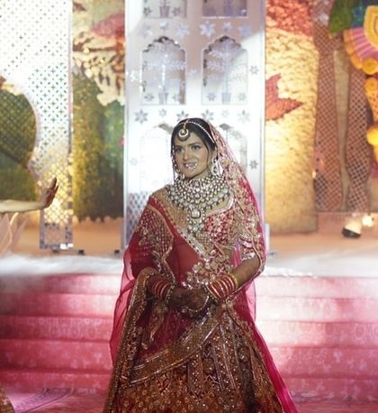 A beautiful portrait of the bride during her grand Jaimala entry. Surrounded by our dancers and a stunning, larger-than-life floral backdrop, she looks every bit the radiant queen of the night.