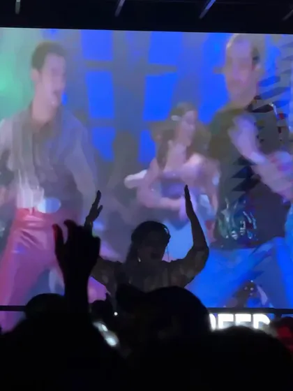 A silhouette of me against a screen playing a classic Bollywood dance number.