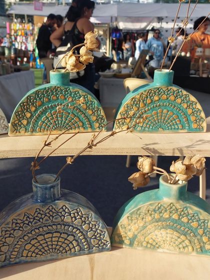 My half-moon shaped vases on display at The Lil Flea market. The intricate lace texture and beautiful turquoise glaze make them a customer favorite.
