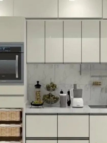 A sleek, all-white modular kitchen with handleless cabinets for a minimalist look. The design incorporates an integrated oven and pull-out wicker baskets for vegetable storage.