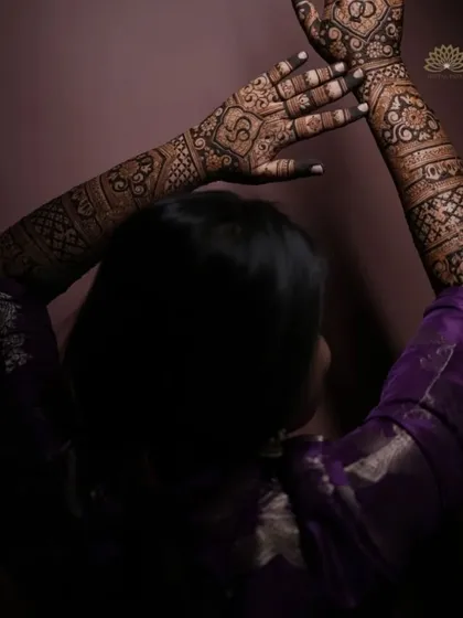 An artistic shot of a client showcasing her full-arm engagement mehndi, with the dark stain beautifully captured.