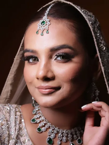 A classic bridal pose that shows off the complete look, from the makeup to the stunning diamond and emerald jewelry.