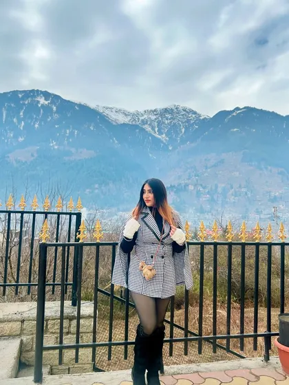 Another pose in the NewMe dress, showing off my winter accessories. I focus on creating a complete, styled look for my travel content.