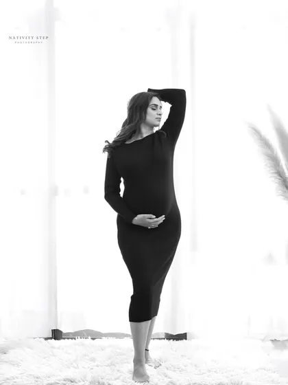 A modern and artistic black and white pose. The high-key background and the strong lines of the pose create a fashionable and striking image.