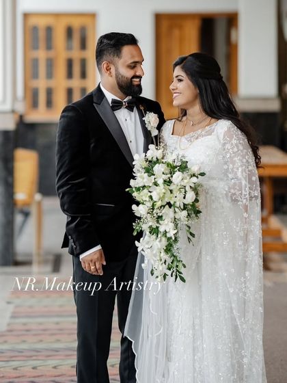 A beautiful portrait of a Christian couple after their wedding. The bride is wearing a unique saree-style gown, and her makeup is soft and romantic.
