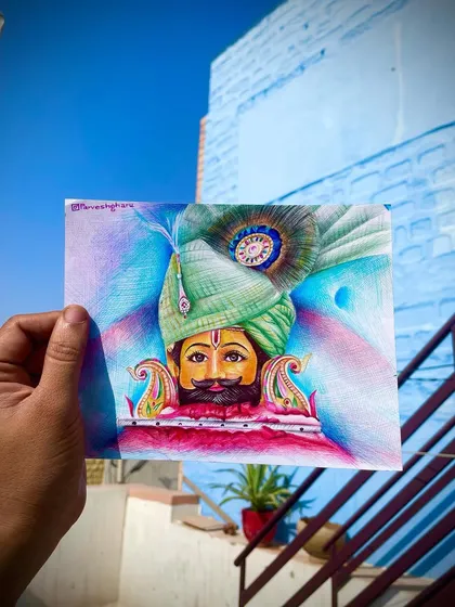 The finished colored pen sketch of Baba Shyam, held up for display. The vibrant colors of the turban and the background create a powerful and devotional image.