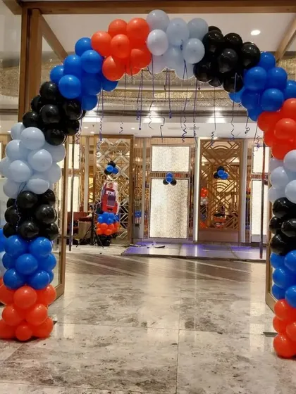 A balloon archway entrance for a 'Cars' themed party, setting the tone right from the start with red, black, blue, and white balloons.