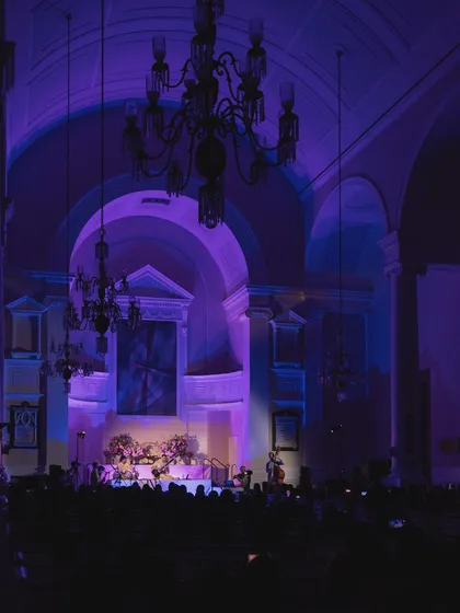 The entire hall bathed in purple light, creating a dreamlike atmosphere for the performance. The lighting and visuals are carefully designed to complement the emotional journey of the music.