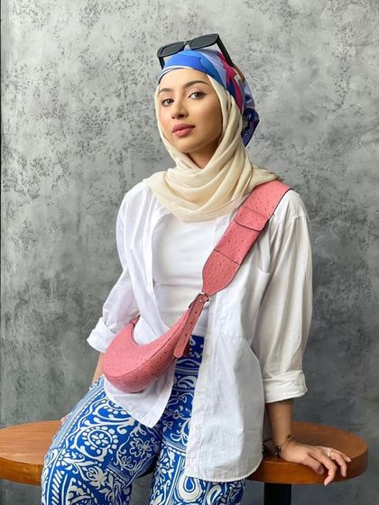 The Selena in Pink Ostrich, styled beautifully with a hijab. The soft pink and unique texture of the bag add a touch of elegance and a pop of color.