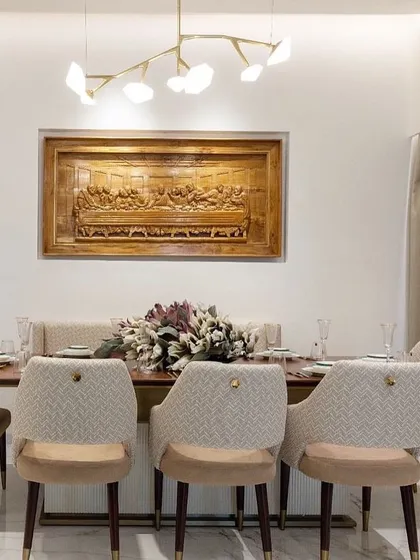 A closer view of the dining set, highlighting the texture of the quilted chair backs and the warm, inviting feel of the space.