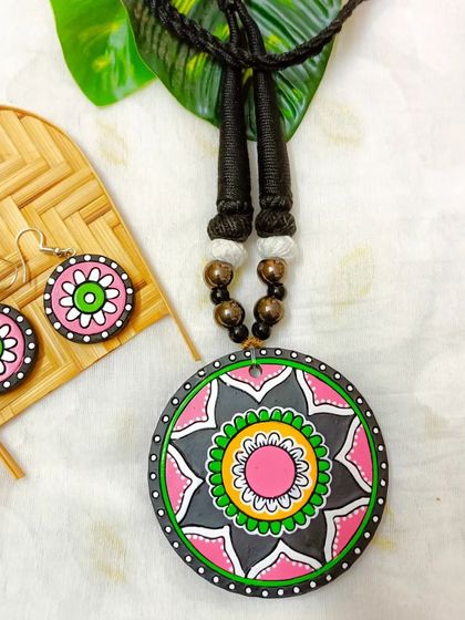 The same circular mandala pendant necklace, here in a pretty pink, green, and gray combination.