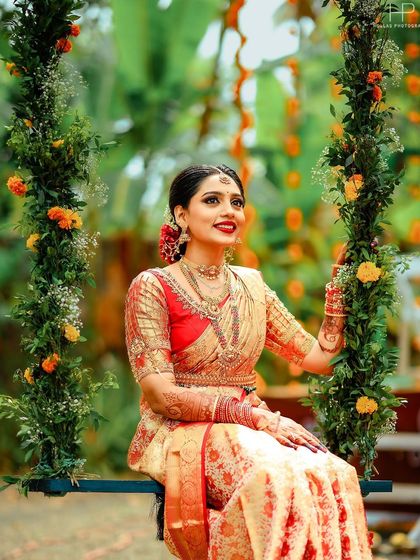 A serene portrait of the bride on the floral swing, looking radiant in her traditional attire.