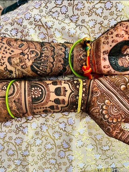 A full view of a narrative design, with a couple portrait on one palm and a peacock on the other, surrounded by detailed patterns extending up the arms.