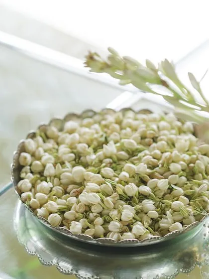 A bowl of fresh jasmine buds, used for both fragrance and as a beautiful, traditional decor element.