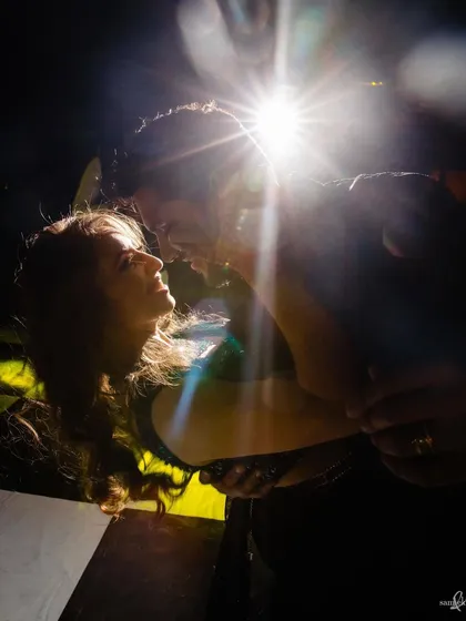 A creative portrait of Priyangi and Kishan, using a flare to create a starburst effect. Their intense connection and the dramatic lighting make for an electric and powerful image.
