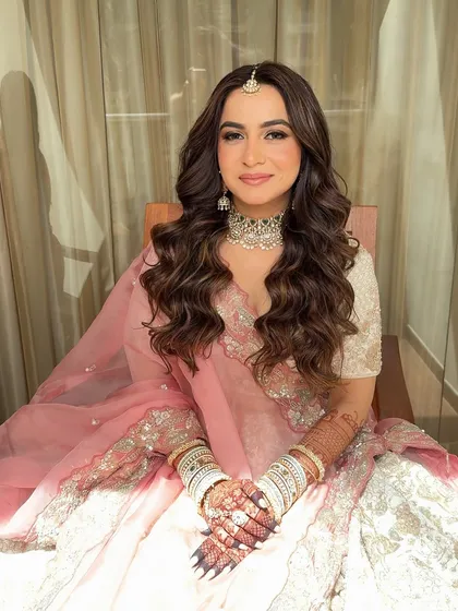 Soft glam and open hair are a match made in heaven. This stunning bridal look in pastel pink features glowing skin and delicate makeup.