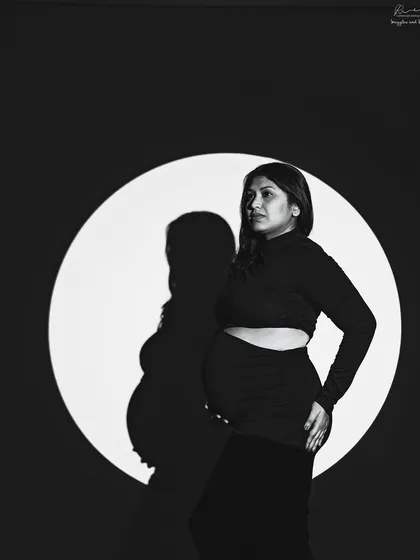 A black and white portrait using a projected circle of light. This creates a powerful graphic element and a unique interplay between the subject and her shadow.