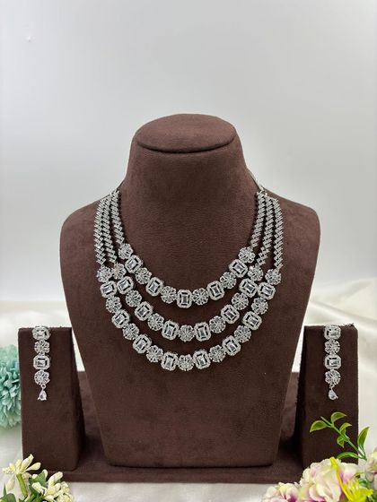 A three-row AD necklace set with square-cut stones. This classic and elegant design is available in all-white, mint green, ruby, blue, and a multi-color option.